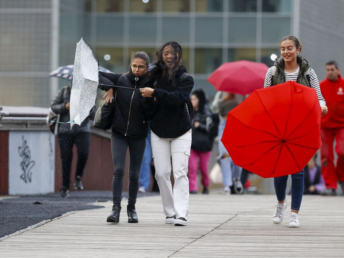 Foto:  Mujeres sujetan sus paraguas por el fuerte viento este martes en Bilbao. (EFE/Luis Tejido)