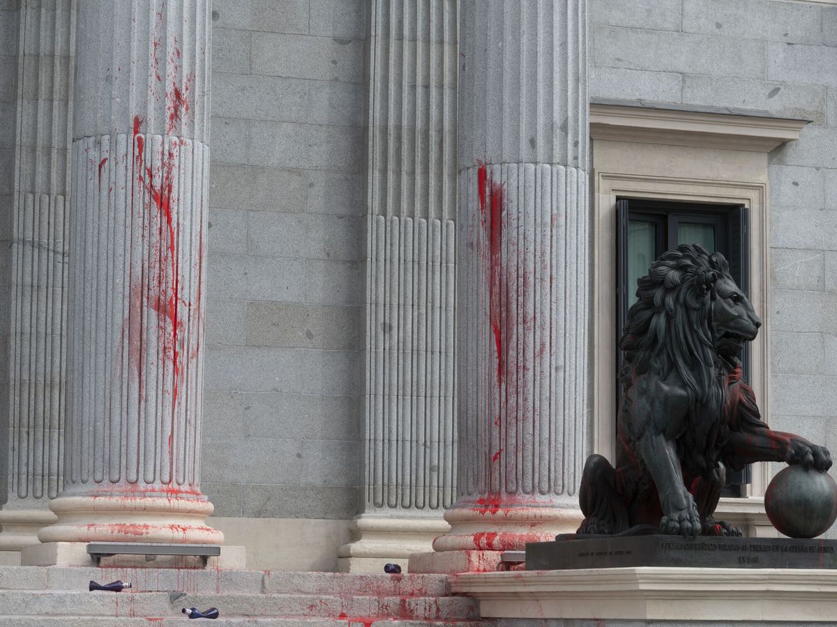 Foto: Uno de los leones del Congreso, cubierto con pintura roja después de una acción reivindicativa de Rebelión Científica este jueves en Madrid. (EFE/J.J. Guillén)