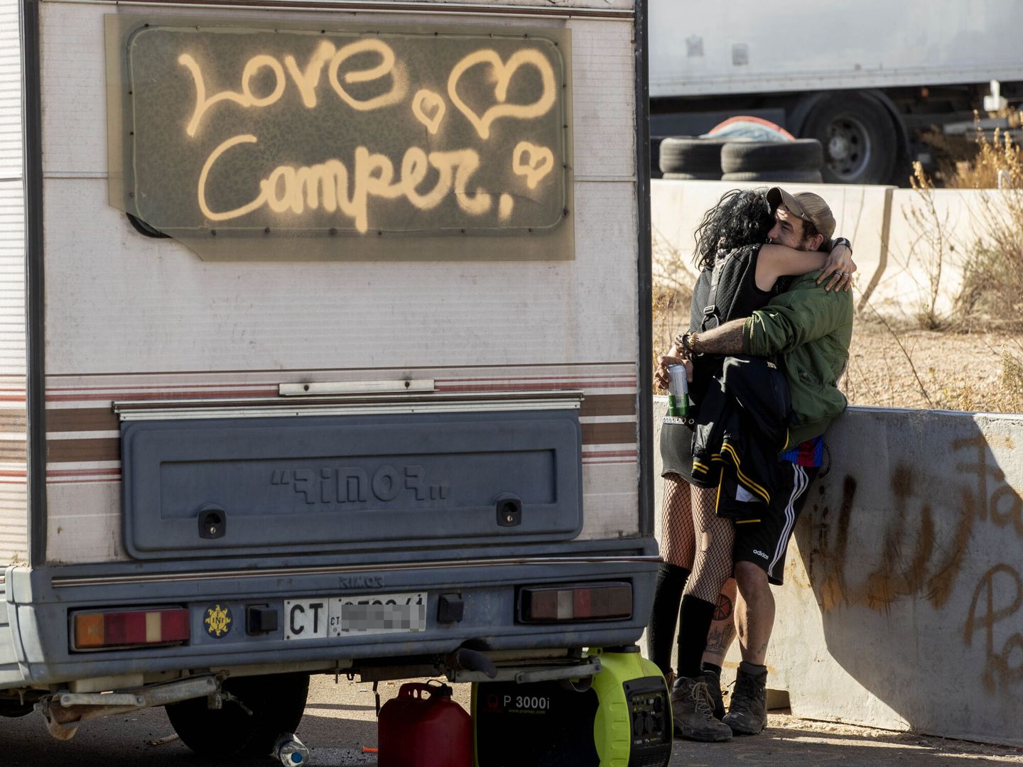 Una pareja, abrazada junto a su caravana en la rave. (EFE)