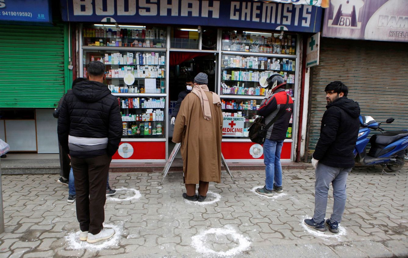 Varias personas haciendo cola para entrar en una farmacia en Srinagar, en el valle de Cachemira. (EFE)