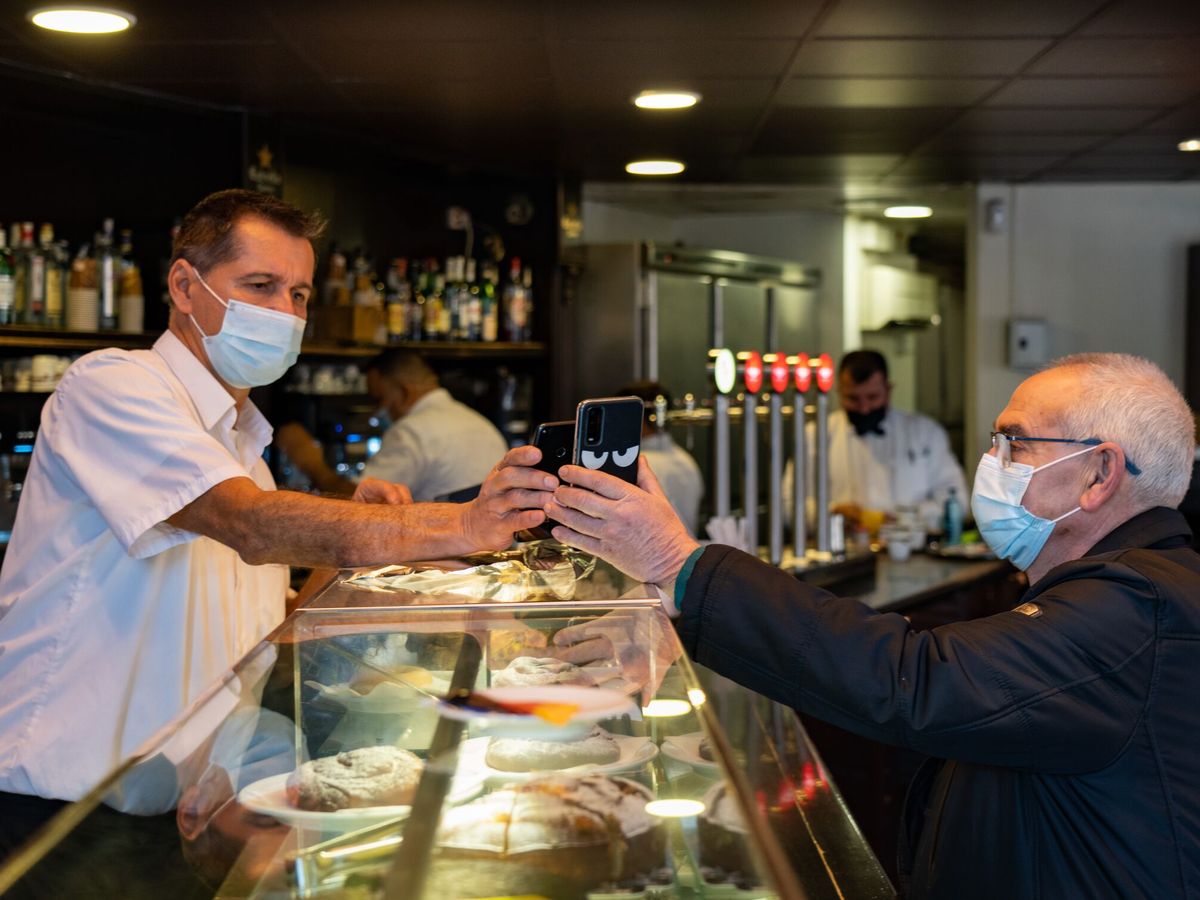 Foto: Un camarero con un cliente en un bar de Barcelona. (EFE/Enric Fontcuberta)
