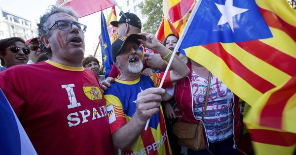 Foto: Un hombre con una bandera independentista (c), junto a otros con banderas españolas. (EFE)