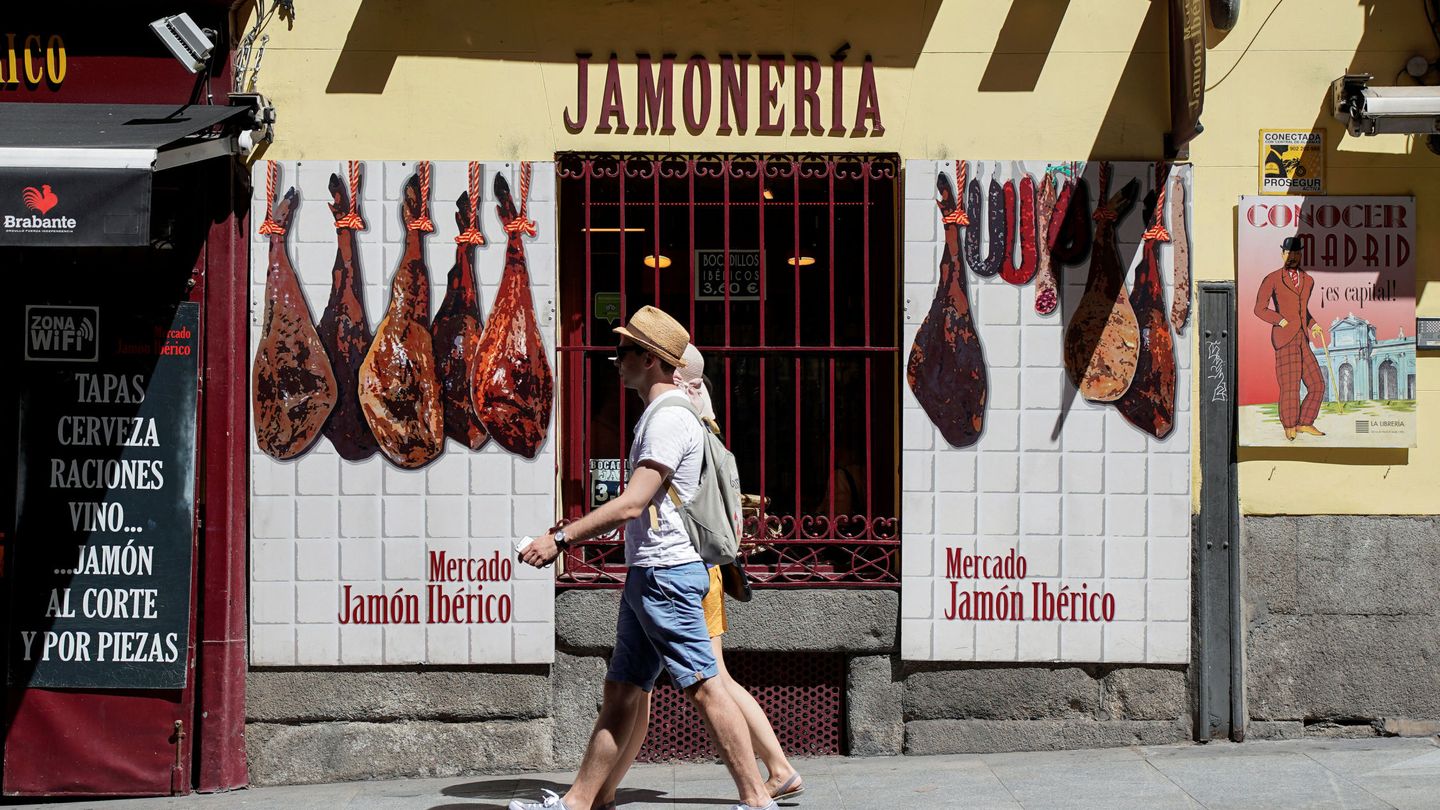 Turistas frente a un negocio especializado en jamones. (Reuters)