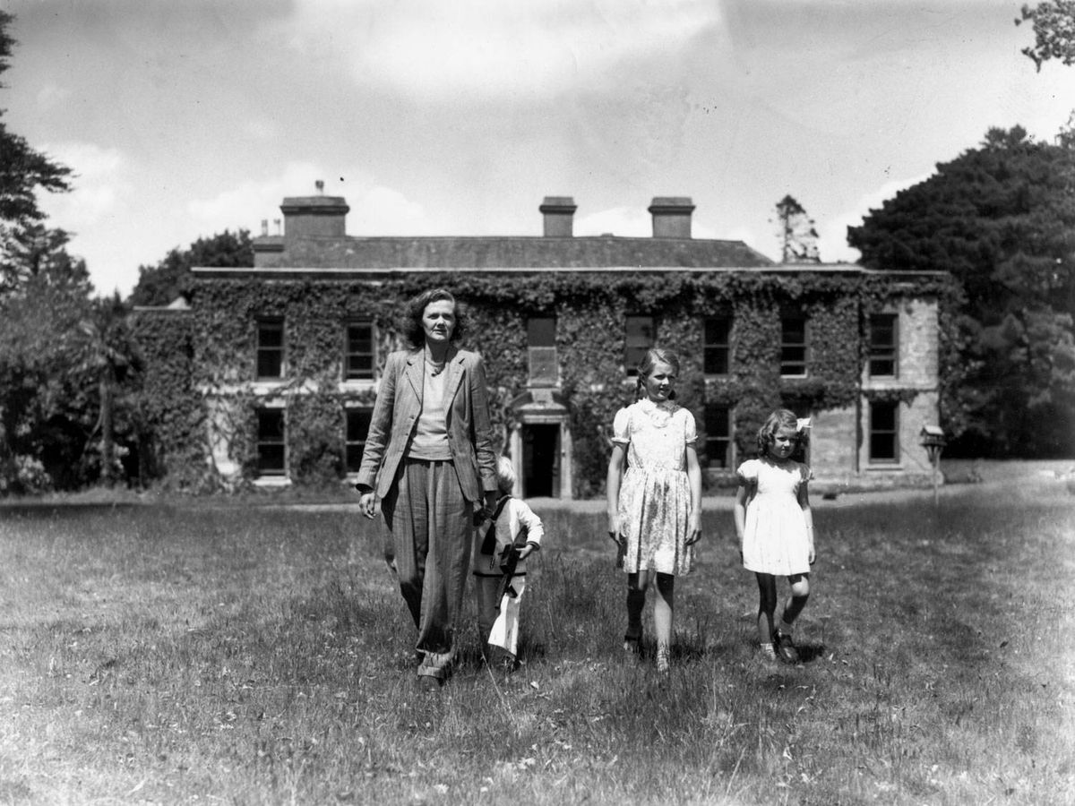Foto: La autora y sus hijos, con la casa al fondo. (Getty)