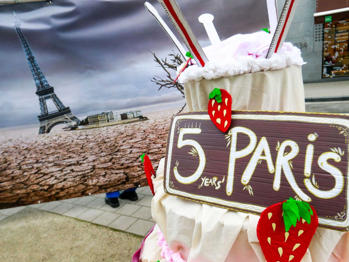 Foto: Activistas climáticos ponen una tarta falsa con motivo de los cinco años que cumple el Acuerdo de París. (EFE)