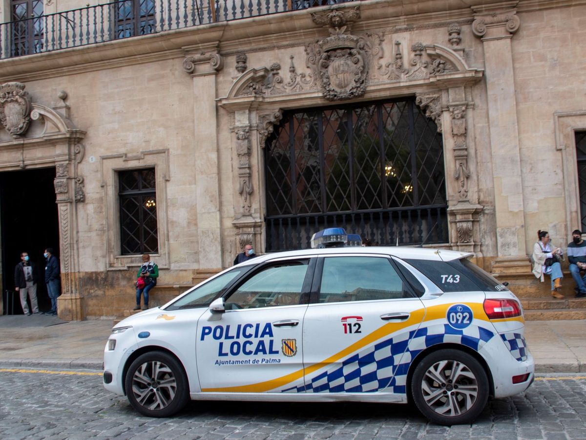 Foto: Un vehíulo de la policía local circula frente al Ayuntamiento de Palma. (EFE/Cati Cladera)