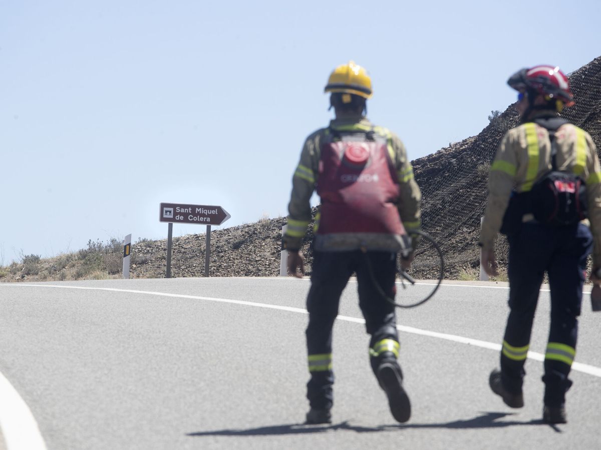 Foto: Dos bomberos caminan por una de las zonas afectadas por el incendio de Portbou. (EFE/Marta Pérez)