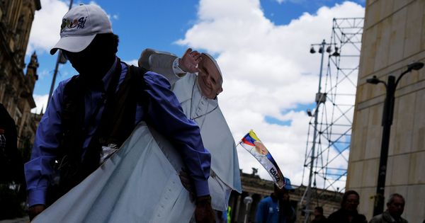 Foto: Un hombre retira una imagen del papa Francisco después de su visita en 2007 a Bogotá. (Reuters)
