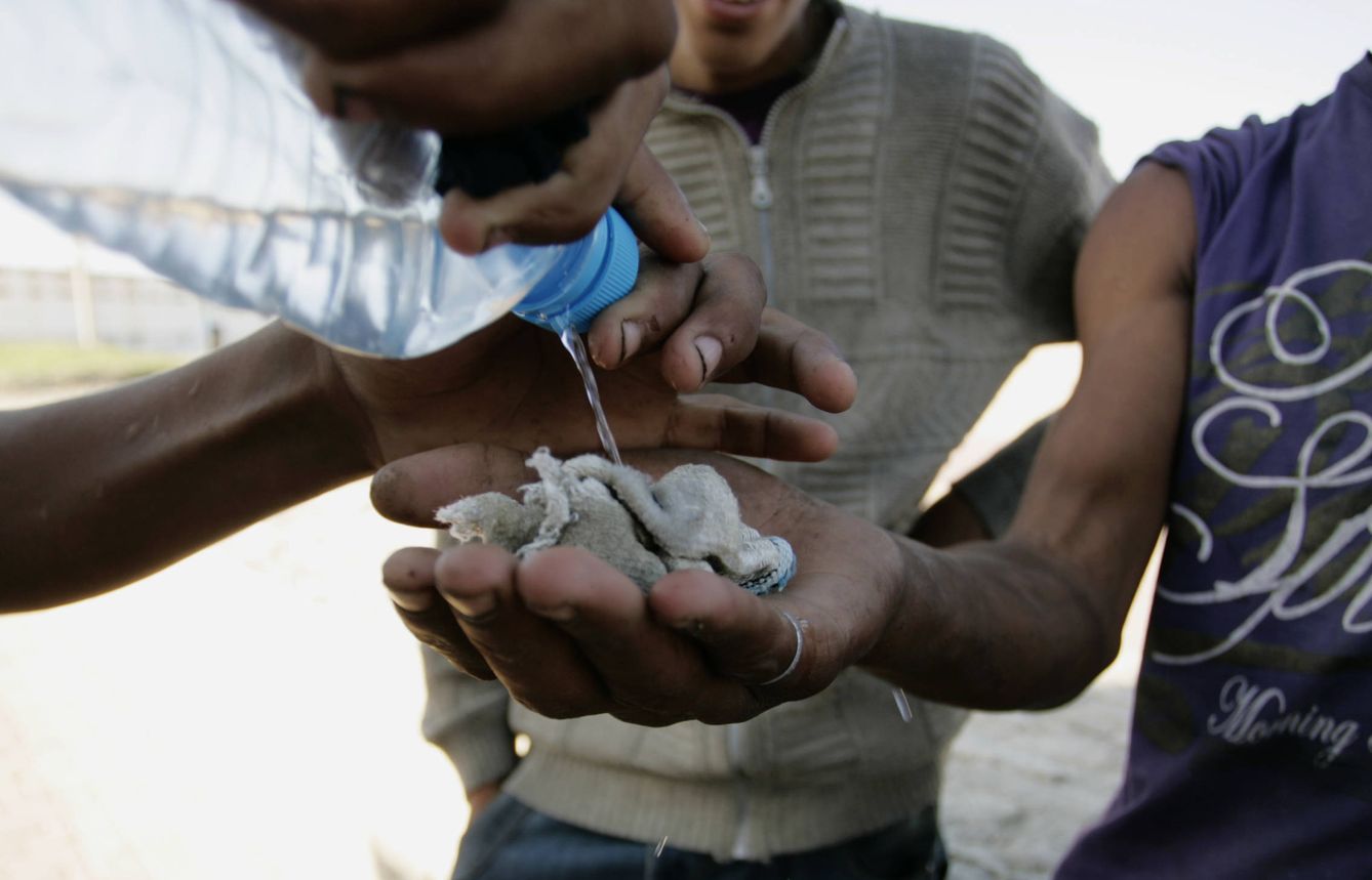 Niños de la calle comparten una botella de pegamento para esnifar en una playa de Tánger en 2009. (Reuters)
