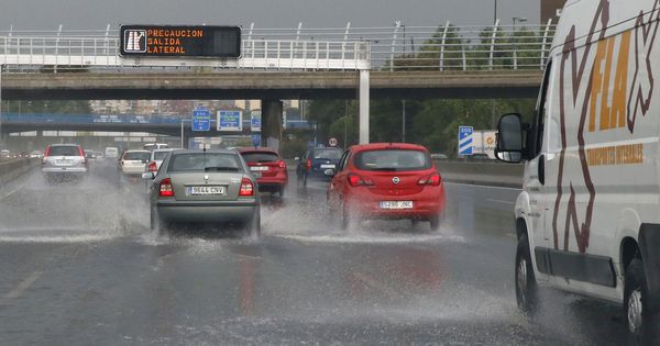 Foto: Los coches circulan por la M-30 madrileña inundada de agua. (EFE)