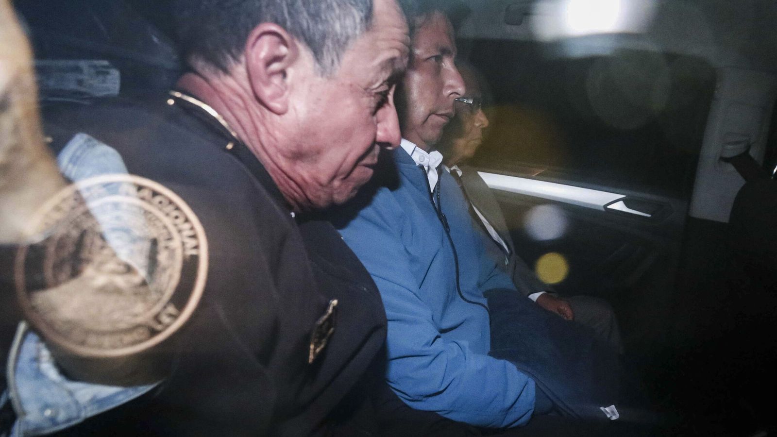 El expresidente Pedro Castillo, flanqueado por agentes de policía durante su arresto. (EFE)