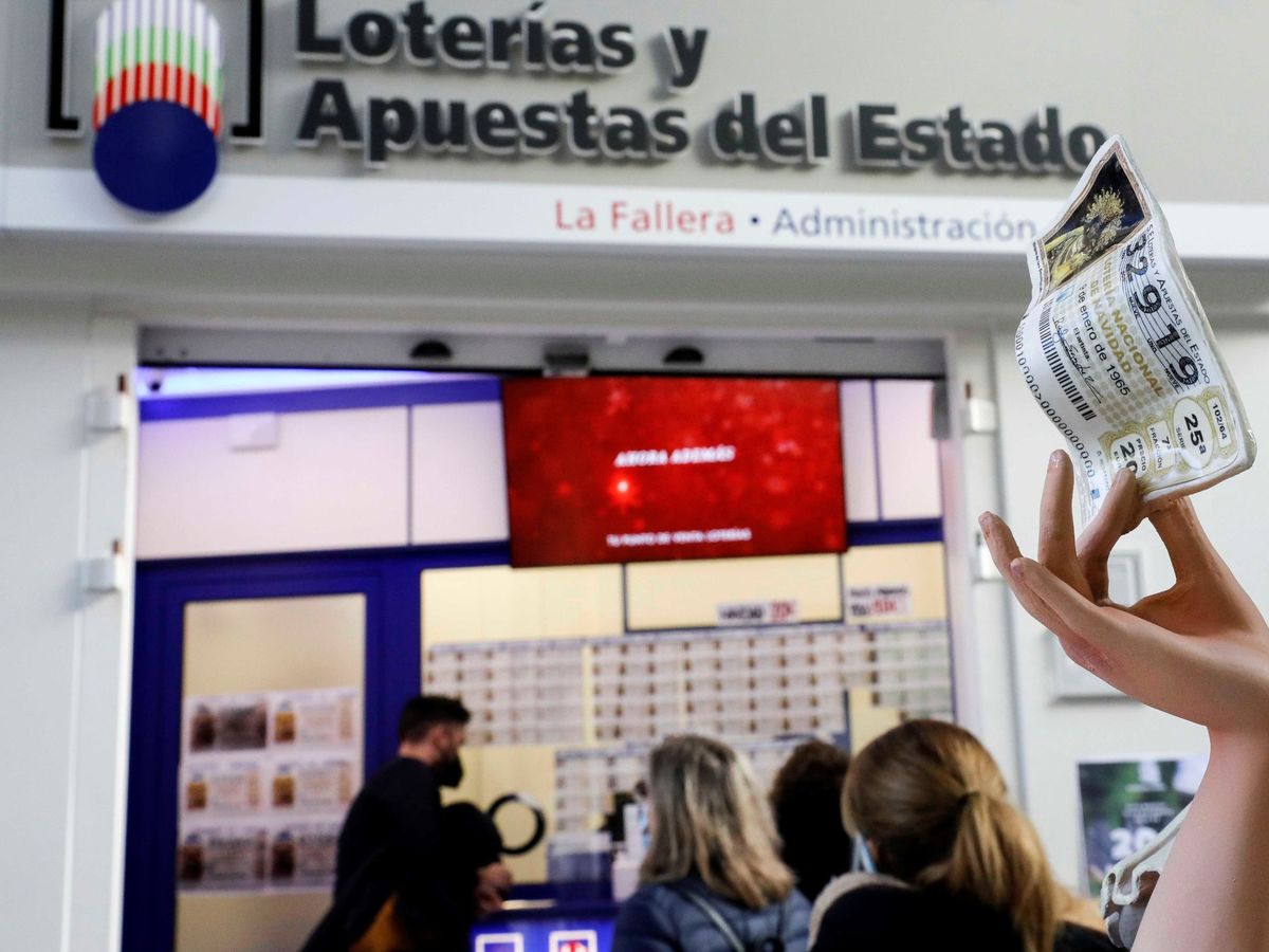 Foto: Varias personas guardan cola para adquirir lotería de Navidad. (EFE)
