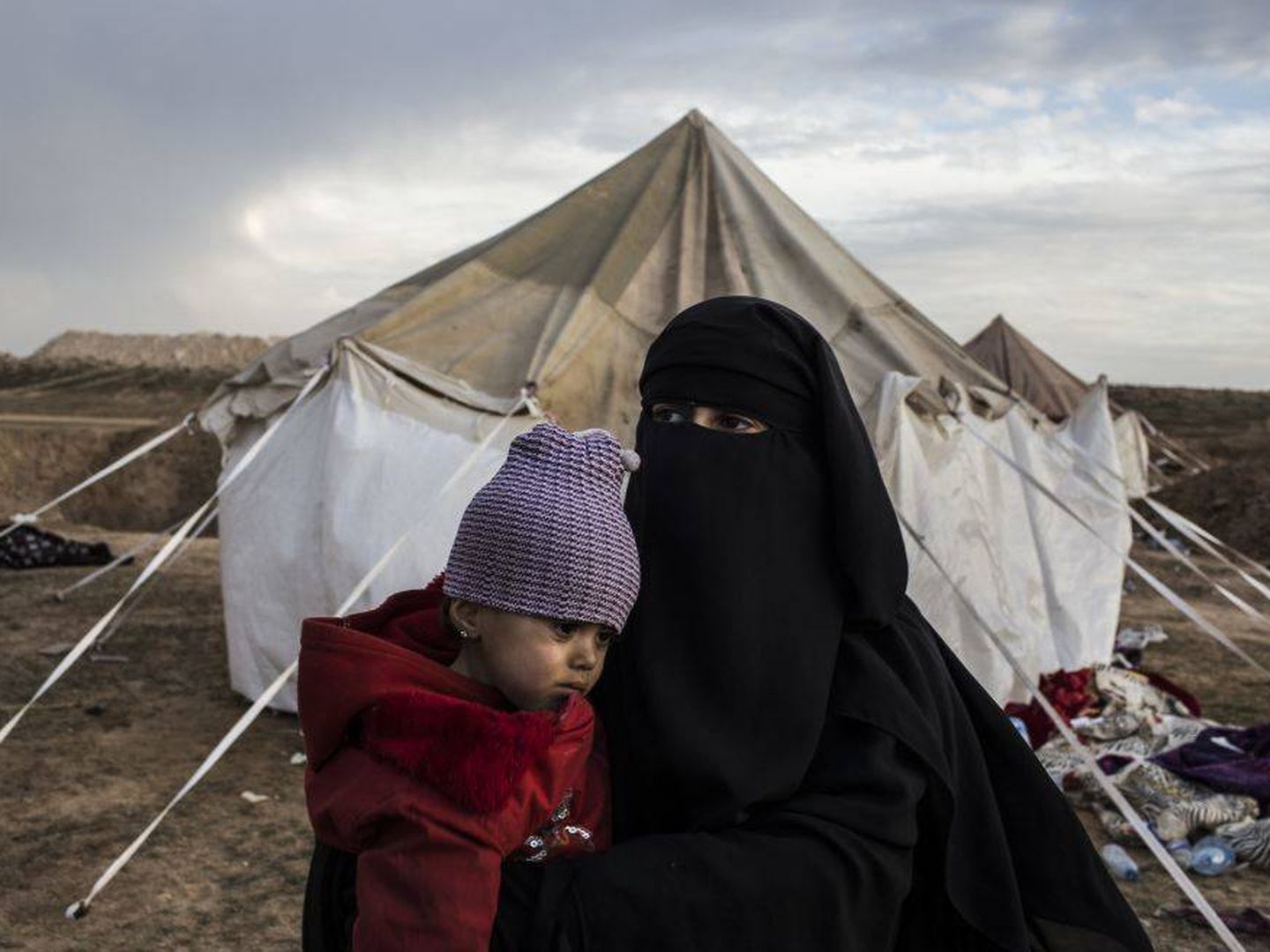 Lina, de 17 años, sostiene uno de sus hijos en brazos en el campo de desplazados donde han llegado huyendo de los combates en Baghuz. (J.M. López)