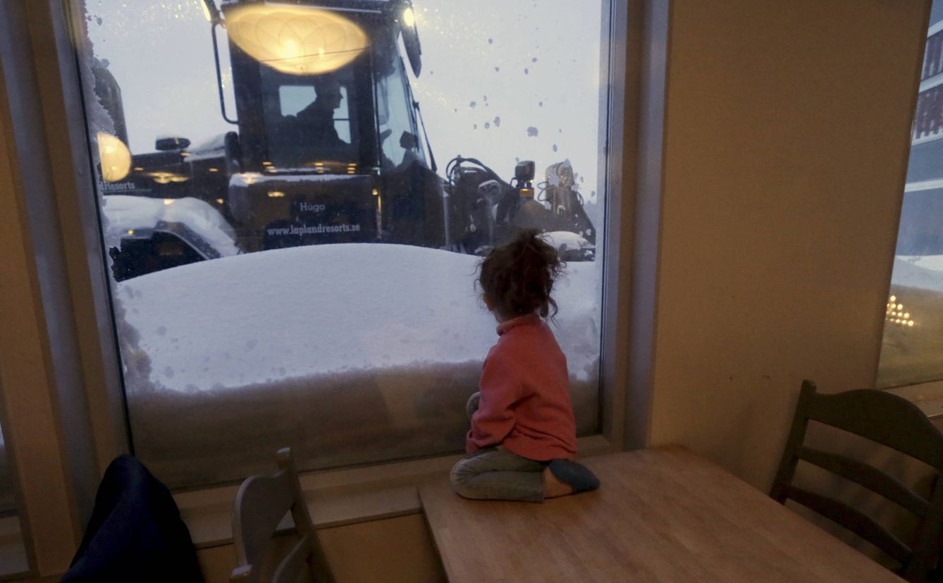 Una niña refugiada mira por la ventana en la estación de esquí de Riksgransen, Suecia. (Reuters)