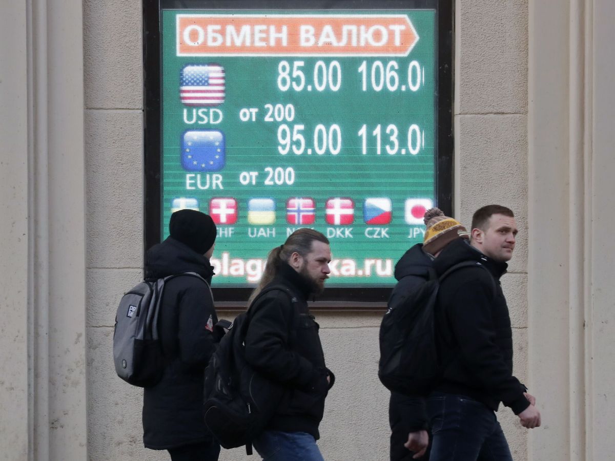 Foto: Rusos frente un panel digital donde se muestra la cotización del dólar y el euro. (EFE EPA ANATOLY MALTSEV)
