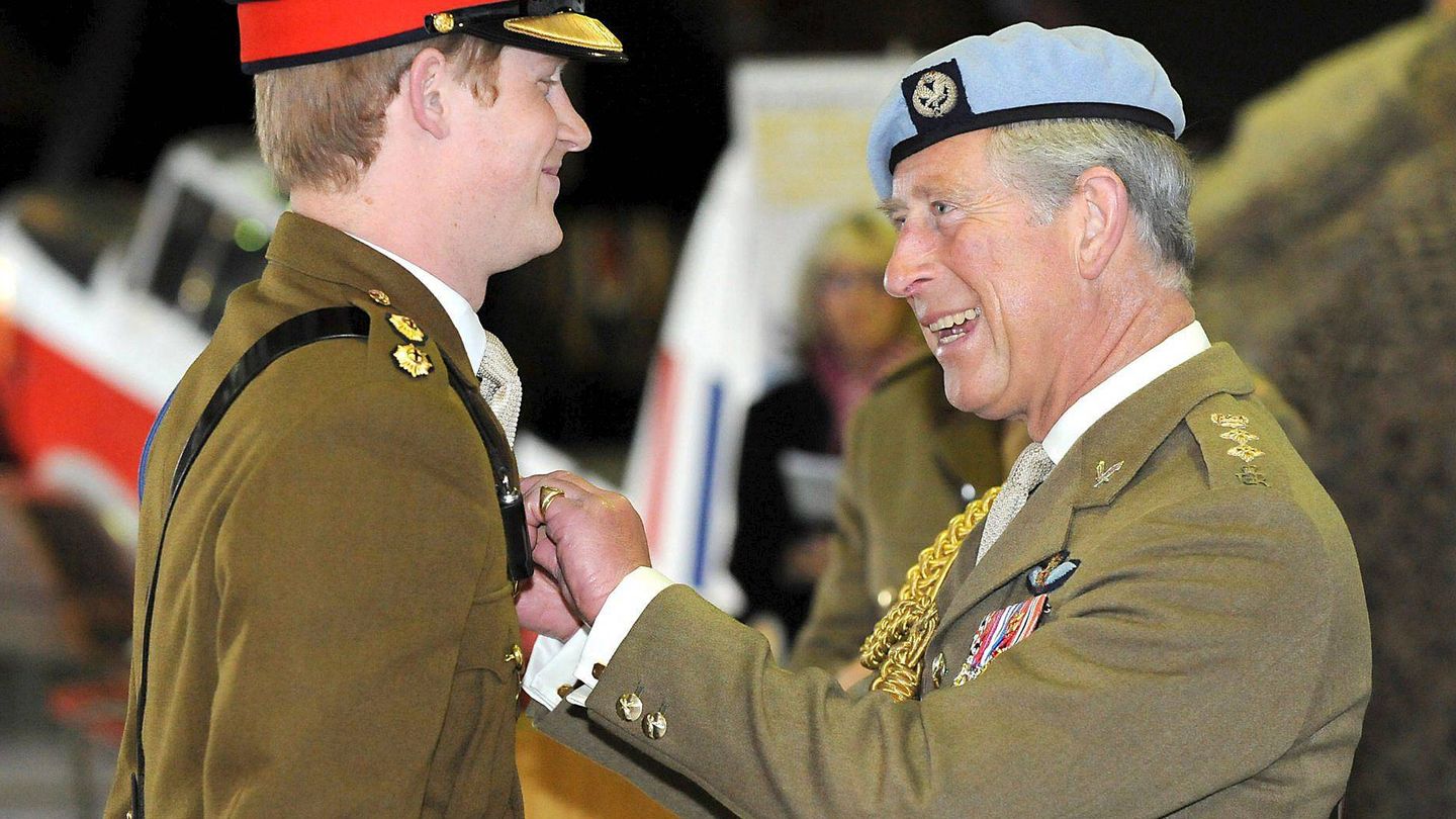 El príncipe Harry recibe de manos de su padre las 'alas' que le acreditan como piloto de helicóptero, en la base militar aérea de Middle Wallop, (Inglatera). (EFE)
