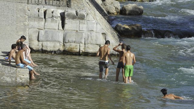 Varios jóvenes se bañan en el río Genil a su paso por Granada capital. (EFE/Miguel Ángel García)