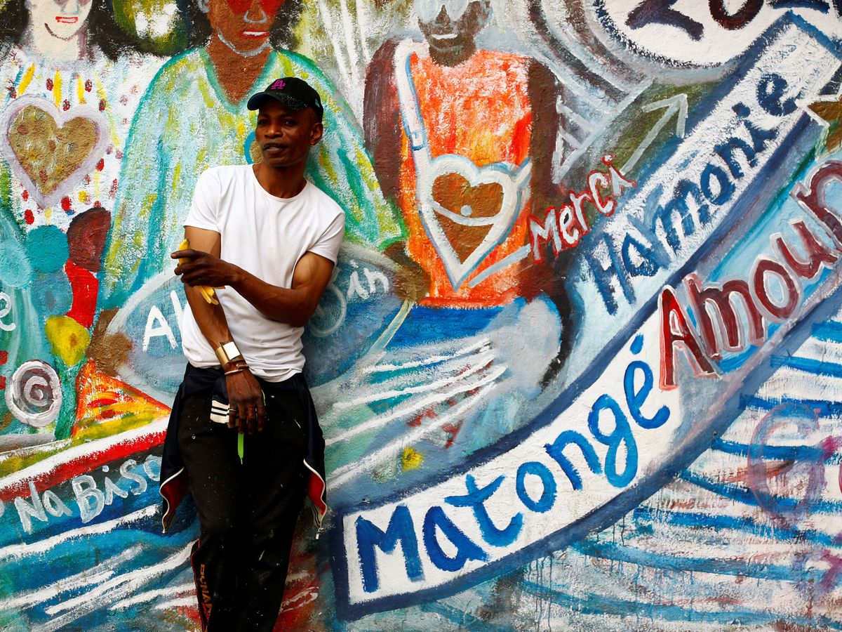 Foto: El artista belga Gael Atumesa posa junto a su fresco en Matongé. (Reuters)