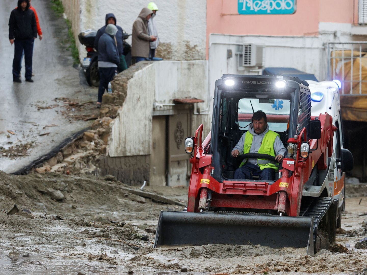 Un hombre con un bulldozer retira el barro tras las inundaciones. (Reuters/Ciro de Luca)