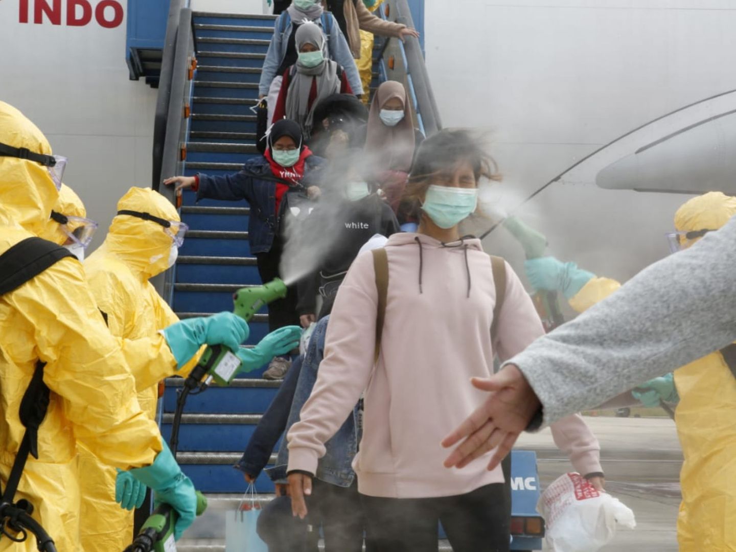 Médicos rocían antisépticos a unos indonesios después de que llegaron del centro de la epidemia de coronavirus de Wuhan, China. (Reuters)