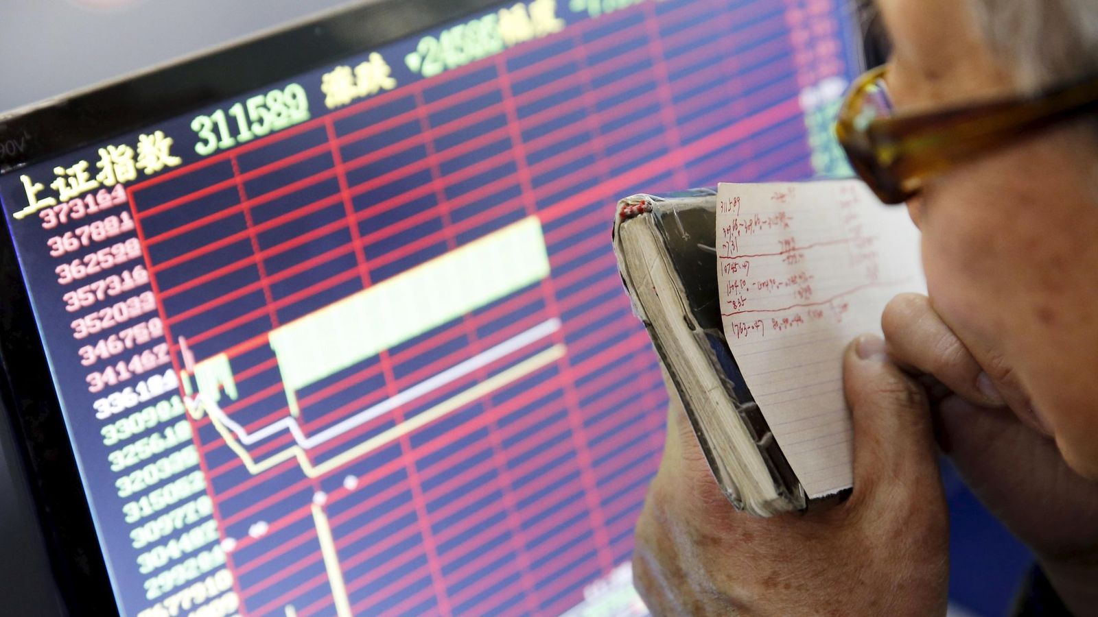 Foto: Un inversor mira uno de los paneles de la bolsa china. (EFE)