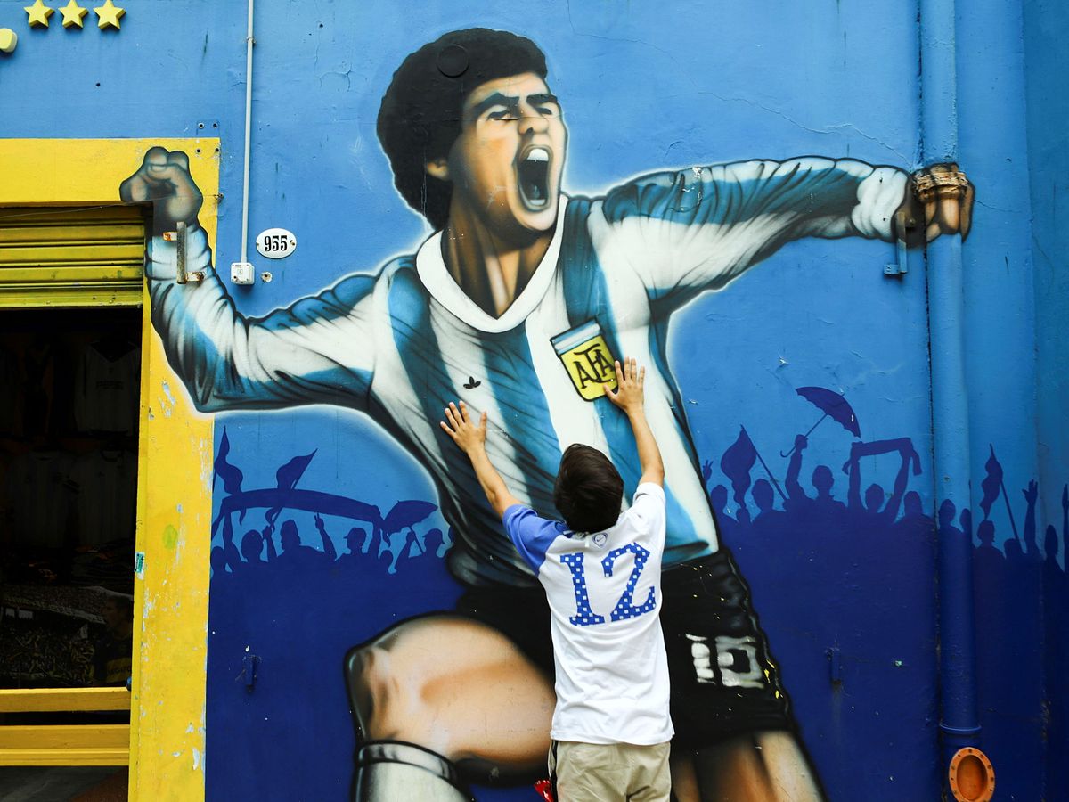 Foto: Mural de Maradona en Buenos Aires, llorado por un niño. (Reuters)