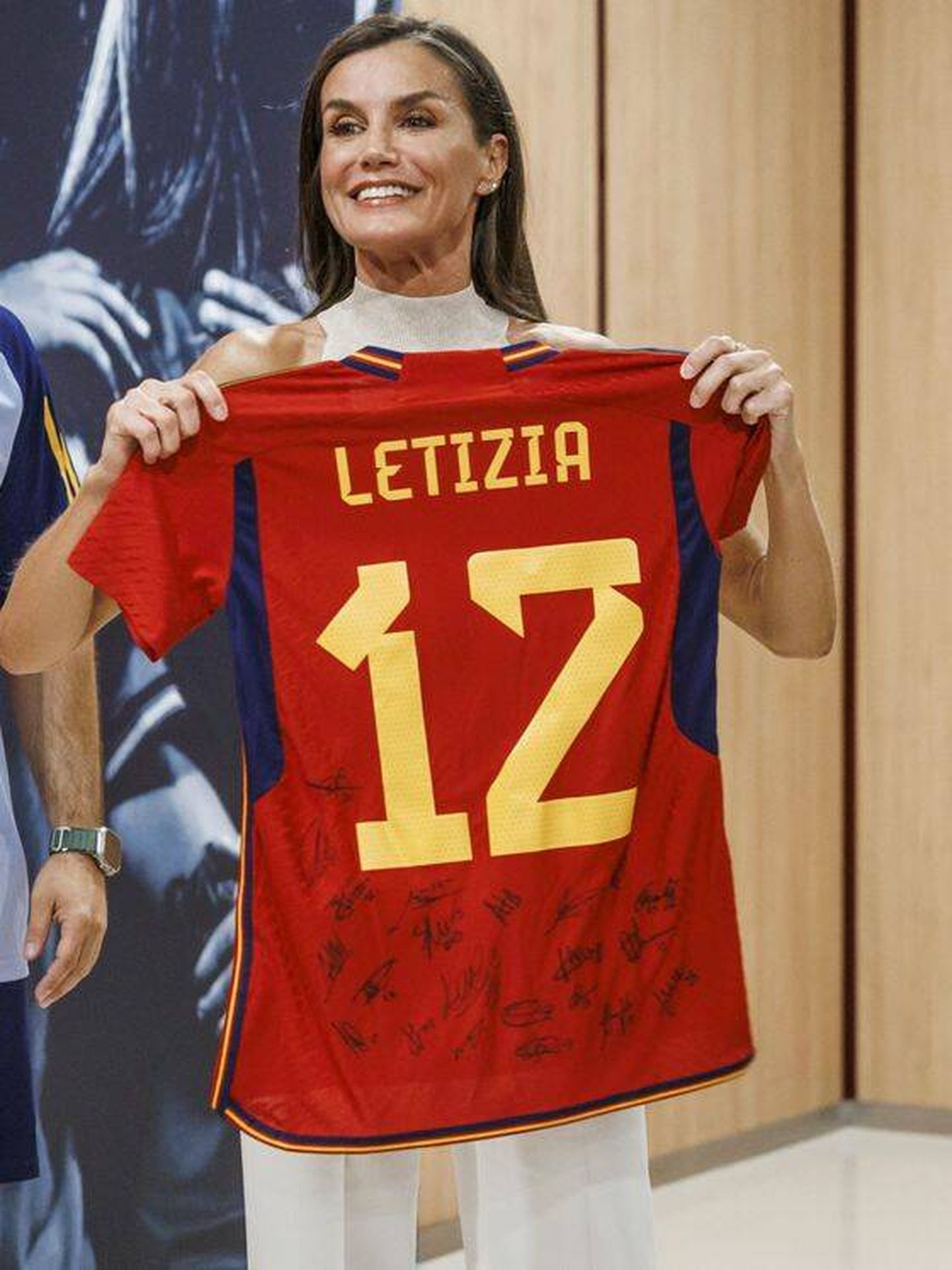 La Reina, feliz con su camiseta firmada de la selección. (EFE)