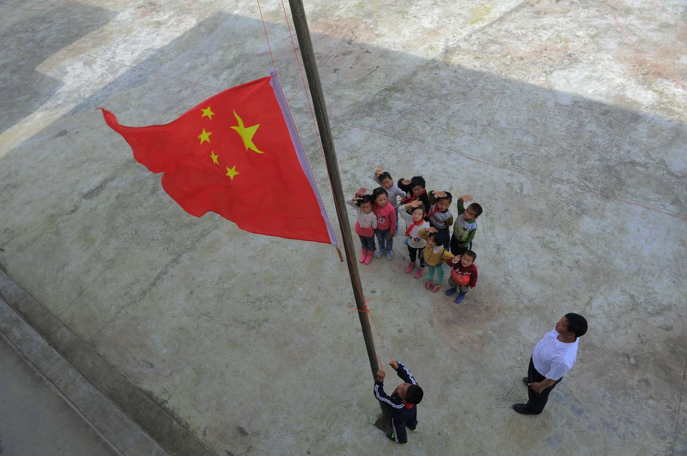 Alumnos chinos de primaria durante una ceremonia de izado de bandera en un colegio de Longli, provincia de Guizhou. (Reuters) 