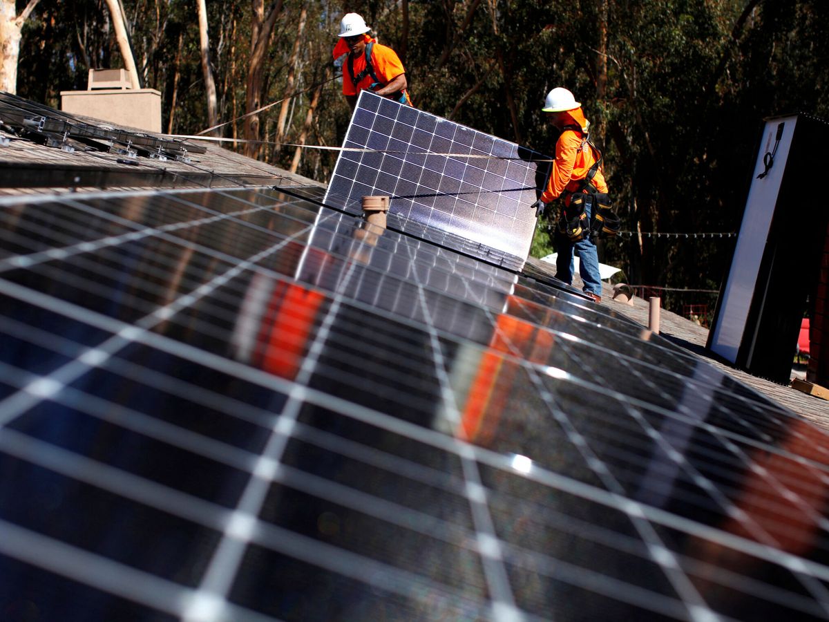Foto: Unos operarios instalan placas solares. (Reuters/Mike Blake)