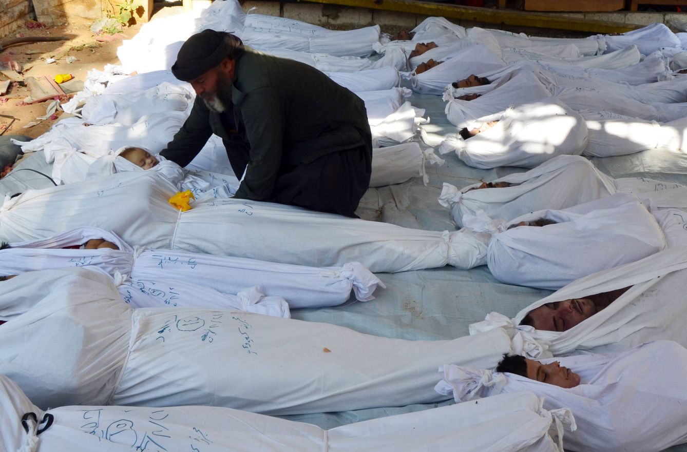 Un hombre sostiene el cadáver de un niño tras el ataque químico de Guta, en agosto de 2013. (Reuters)