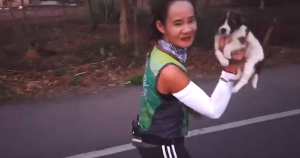 Foto: Khemjira Klongsanun, con el cachorro en brazos durante el maratón (Foto: YouTube)