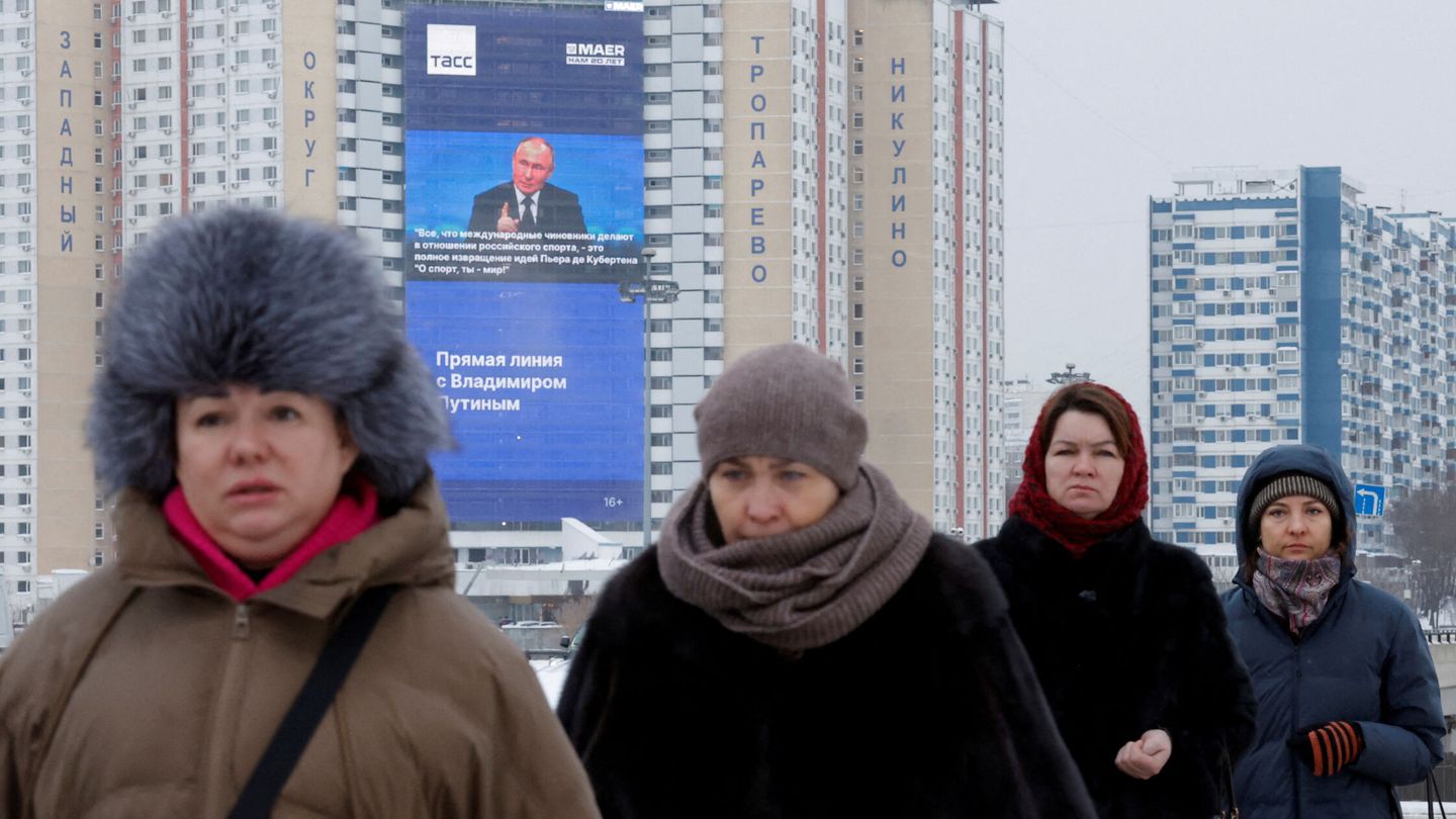Unas mujeres caminan cerca de una pantalla electrónica en la fachada de un edificio que muestra una imagen del presidente ruso, Vladímir Putin. (Reuters/Maxim Shemetov)