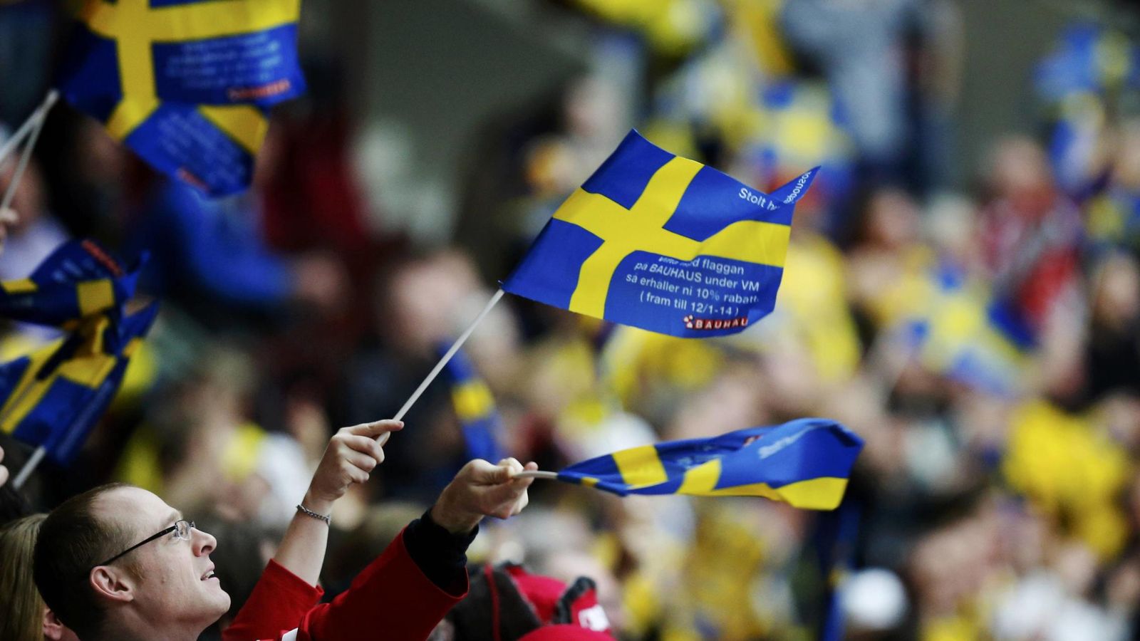 Foto: Un aficionado ondea una bandera sueca durante un partido de hockey hielo. (Reuters)