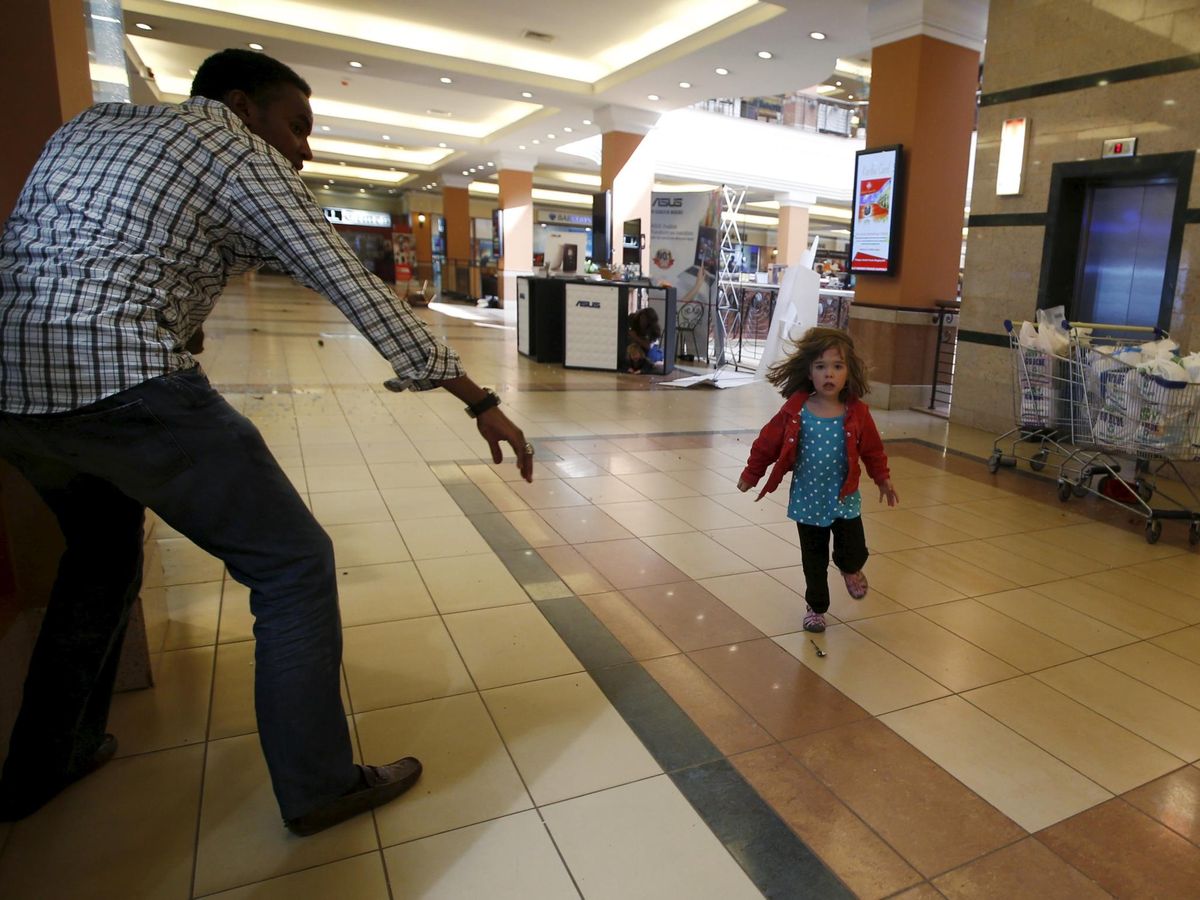 Foto: Abdoul ayuda a una niña a huir del atentado terrorista contra el centro comercial Westgate, en Nairobi (Reuters/Goran Tomasevic)