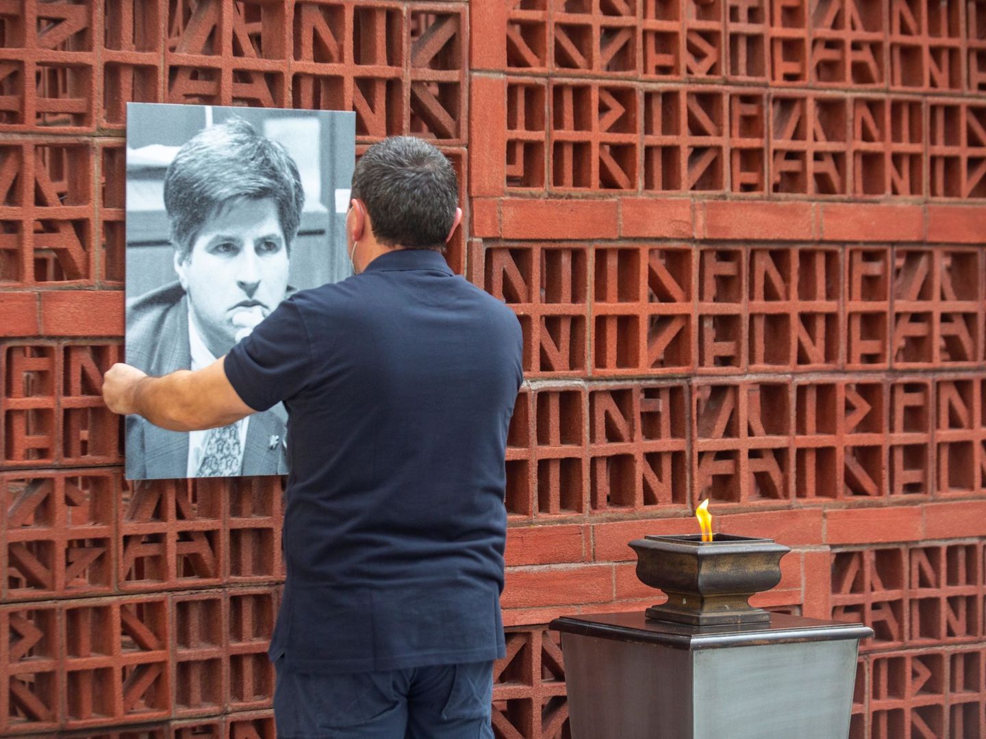 Un operario del Parlamento Vasco coloca un retrato de Ordóñez, hoy, para conmemorar su asesinato. (EFE)