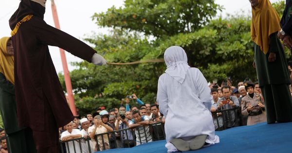 Foto: Una mujer recibe latigazos en público acusado de mantener relaciones sexuales fuera del matrimonio en Banda Aceh, Indonesia. (EFE)