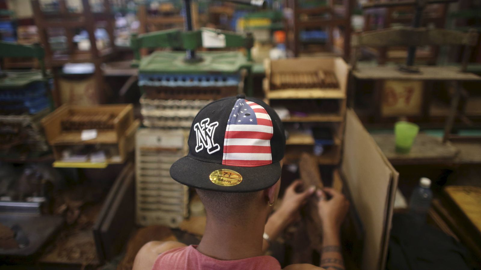 Foto: Un trabajador con una gorra con los colores de la bandera de EEUU en la Fábrica de Tabacos La Corona, en La Habana. (Reuters)   