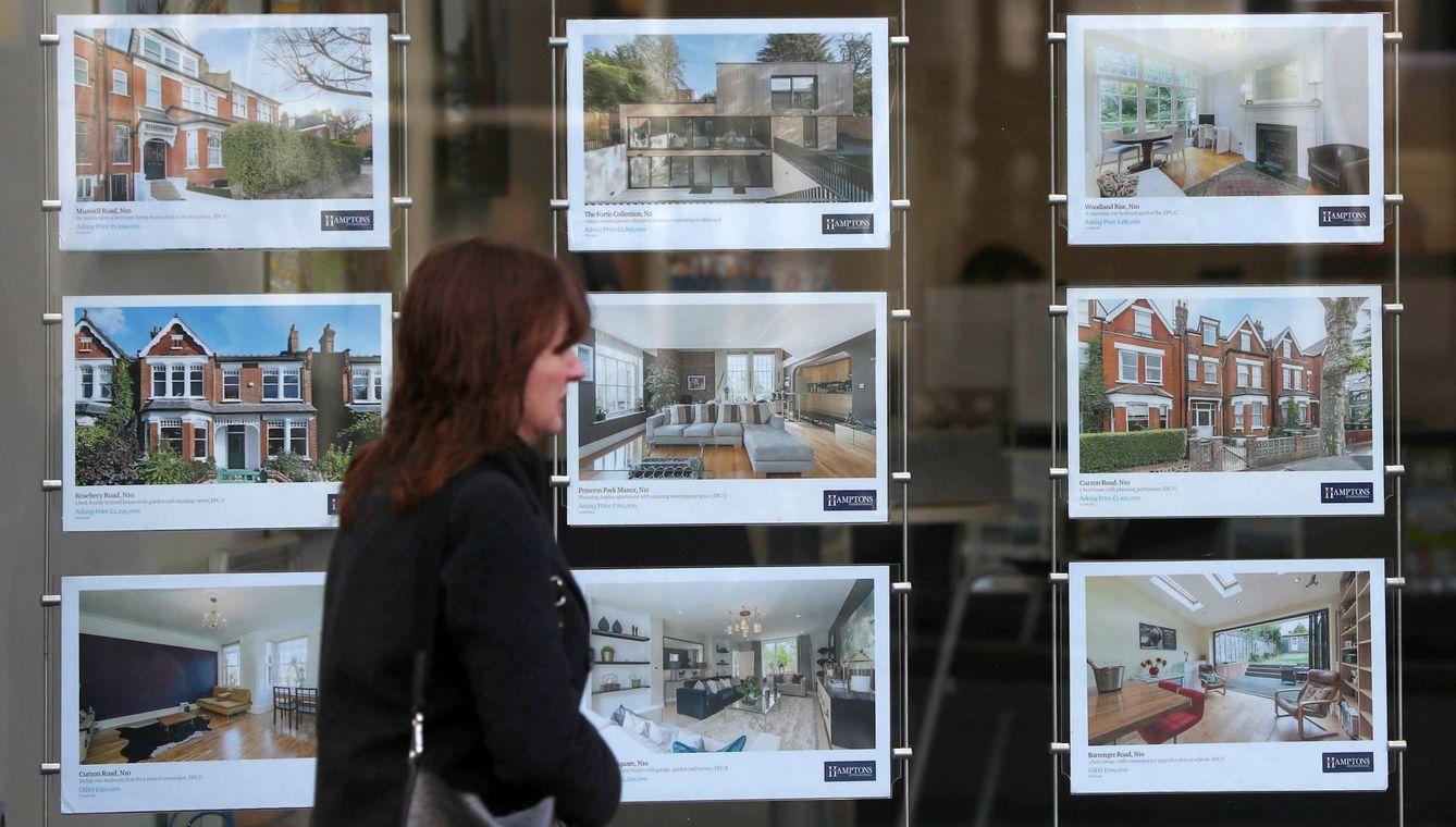 Una mujer pasa frente a un panel de casas en venta en una inmobiliaria. (EFE)