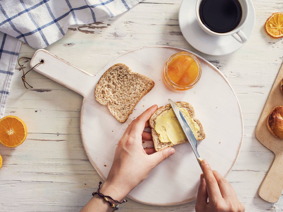 Foto: Imagen de una persona untando mantequilla en su pan (iStock)