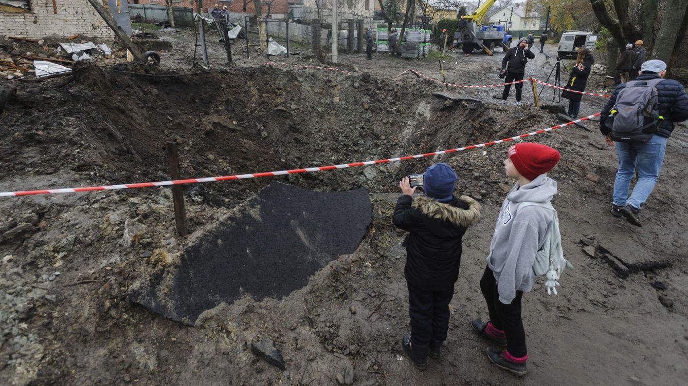 Foto: Los lugareños observan el agujero del bombardeo tras un reciente ataque con cohetes en la aldea de Solonka. (EFE/EPA/Mykola Tys) 