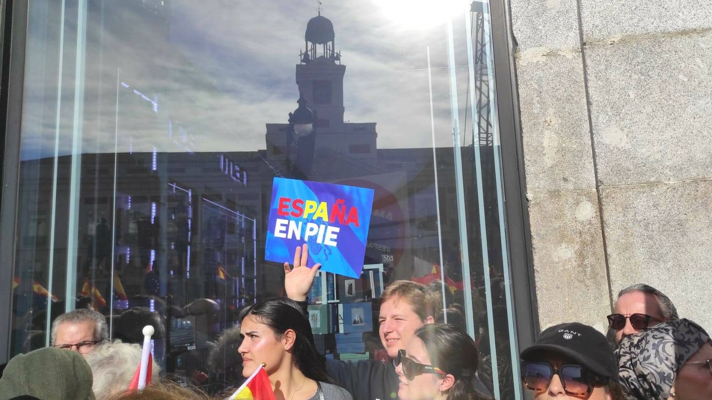 Un manifestante muestra un cartel con el lema 'España en pie', el la Puerta del Sol de Madrid. (L.B.)