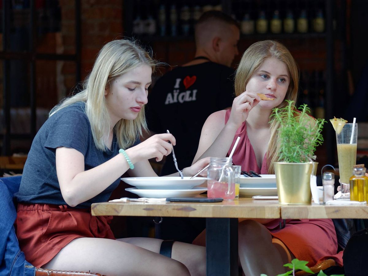 Foto: Dos chicas comen en una terraza de un bar. (Pixabay)