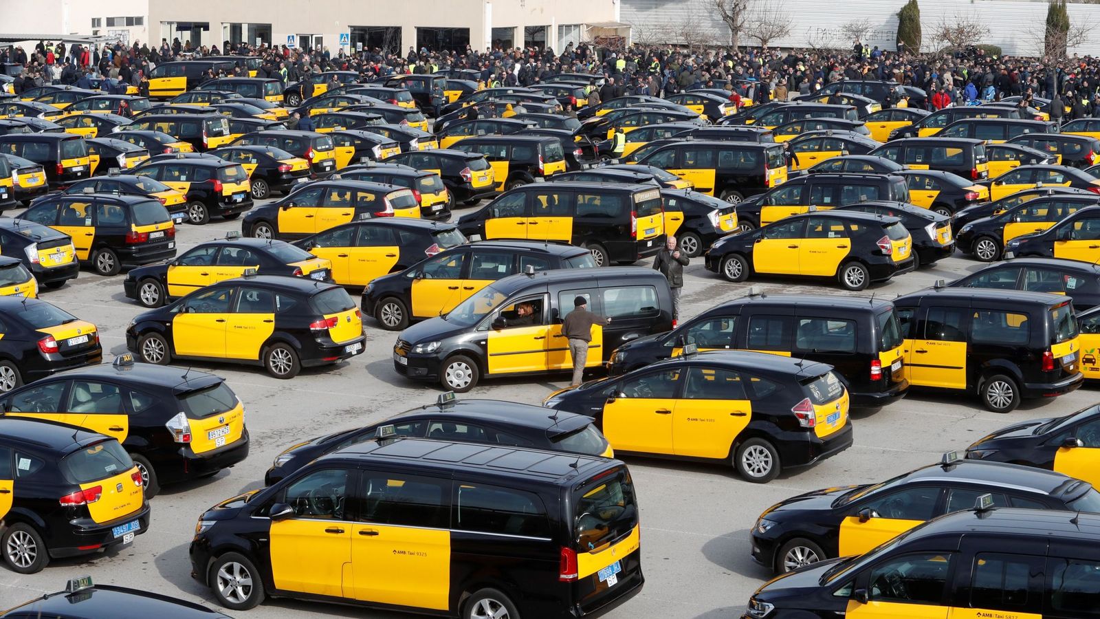 Foto: Centenares de taxistas durante la asamblea que han celebrado en el aparcamiento de la T2 del Aeropuerto de El Prat. (EFE)