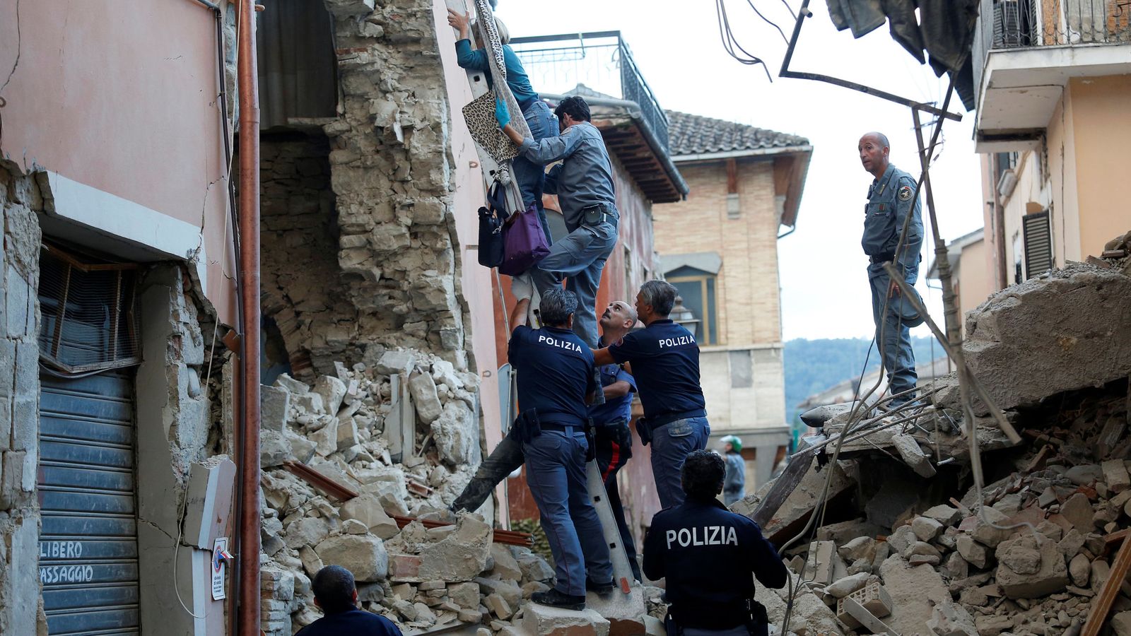 Foto: Ayudan a una mujer a salir de su casa en Amatrice, Italia, tras un grave terremoto. (Reuters)