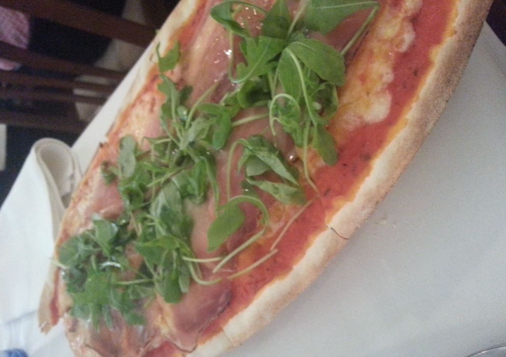 Foto: Pizza de speck con rúcula en formato ovalado