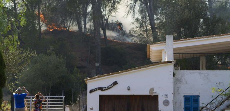 Varias personas observan las llamas del incendio forestal declarado en el municipio mallorquín de Andratx. (EFE)