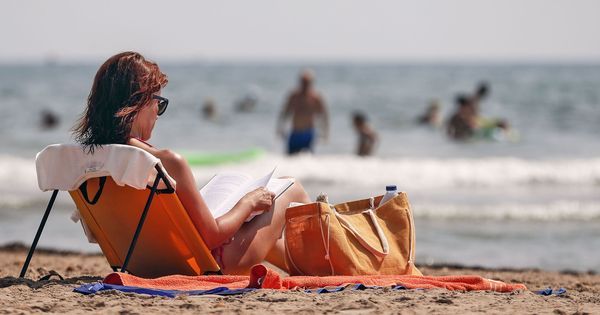 Foto: Una mujer lee en la playa de la Patacona de Alboraya. (EFE)