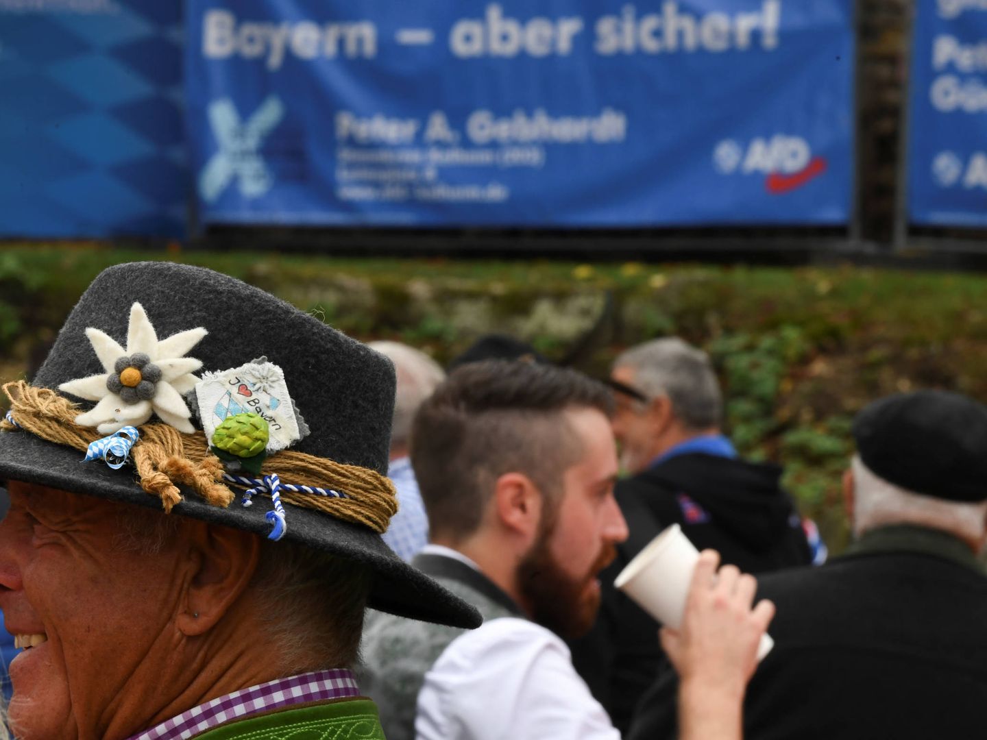 Alemanes durante el festival Gillamoos, en Abensberg. Al fondo, un cartel electoral de AfD. (Reuters)