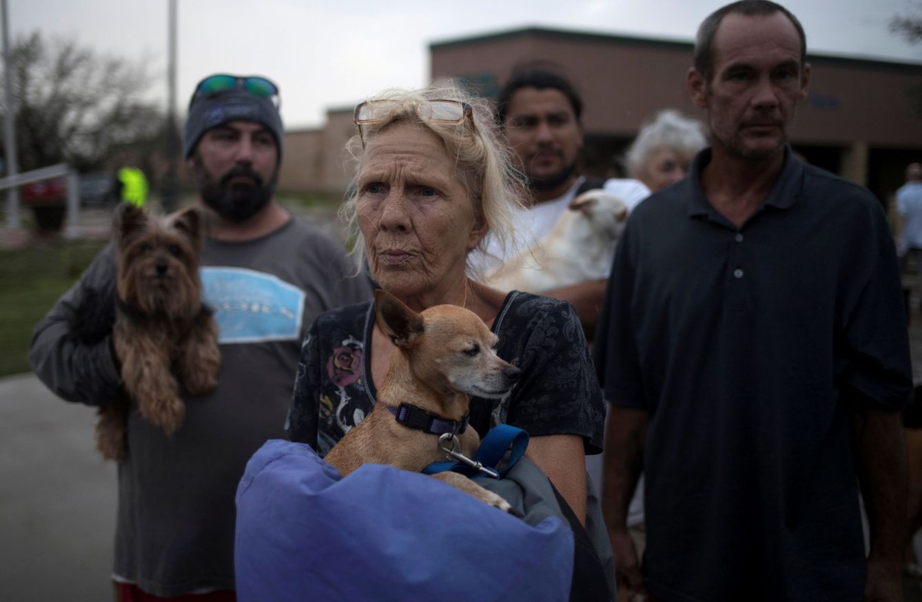 Julie, con su perro en brazos, espera a ser evacuada a Austin desde Rockport. (Reuters)