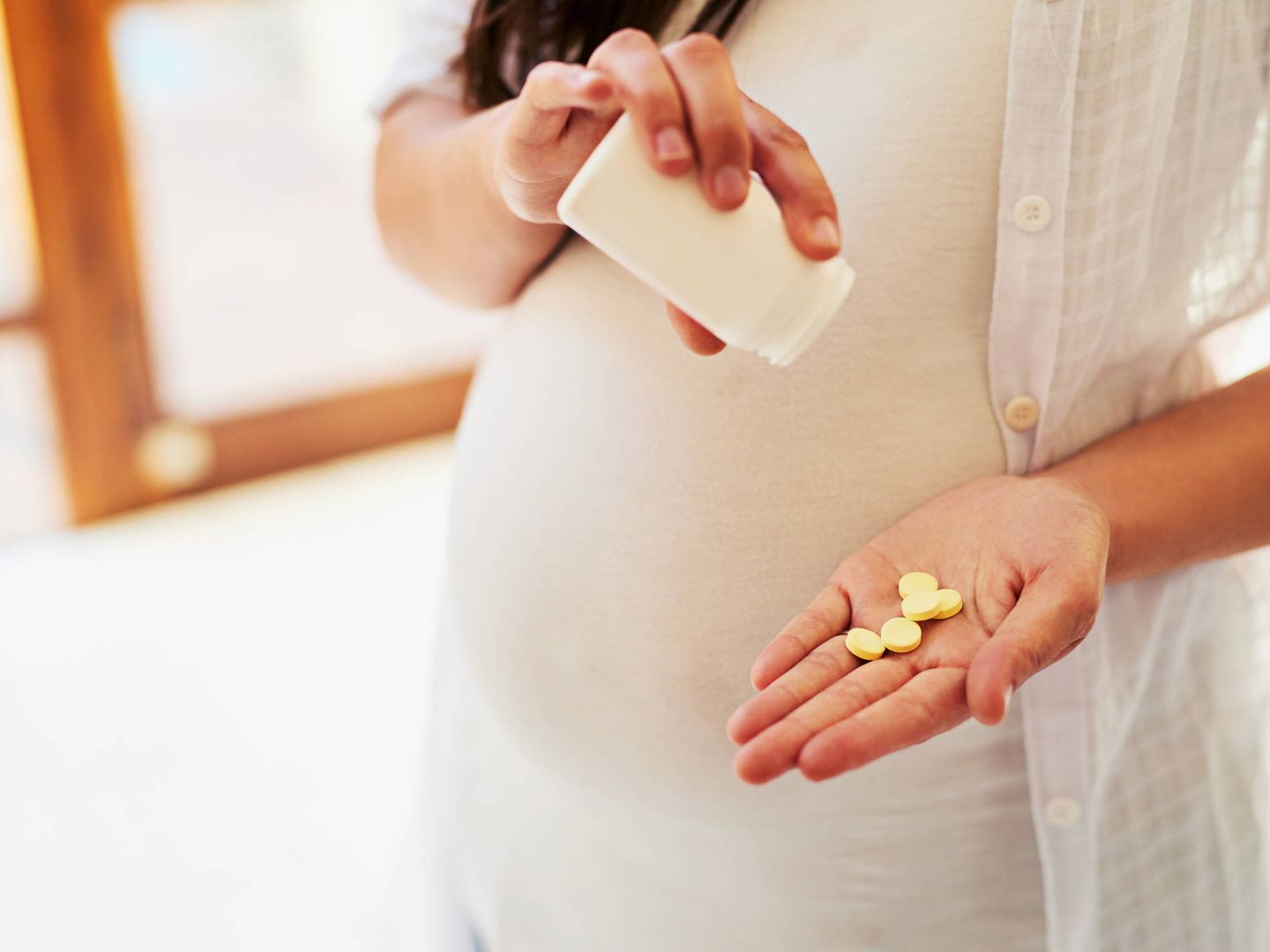 Una mujer embarazada tomando pastillas (Foto: iStock)